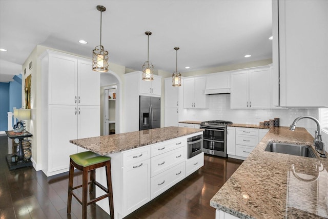 2955 E Stone Creek Blvd, Urbana, IL 61802 - kitchen with appliances with stainless steel finishes, light stone countertops, a center island, recessed lighting, and dark wood finished floors