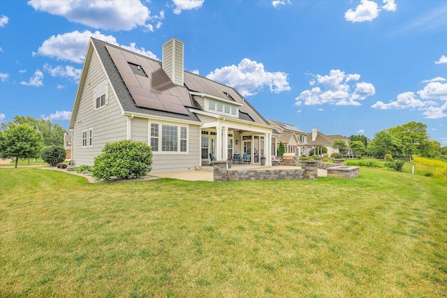 2955 E Stone Creek Blvd, Urbana, IL 61802 - rear view of house featuring a patio, solar panels, a lawn, and a chimney