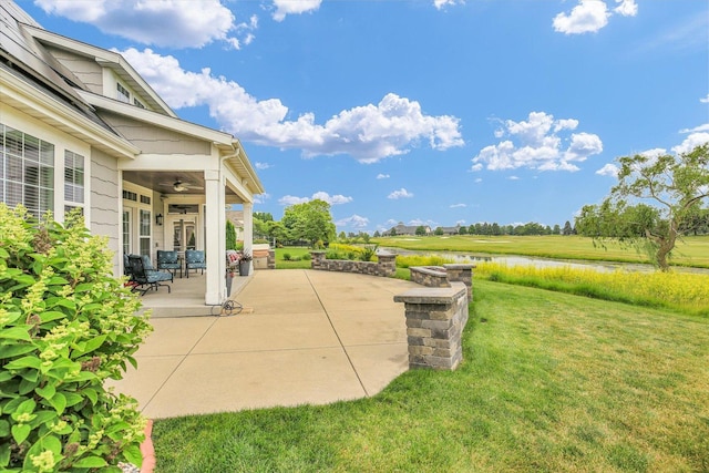 2955 E Stone Creek Blvd, Urbana, IL 61802 - view of green lawn with a patio, ceiling fan, and a water view