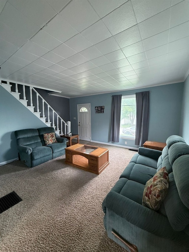 carpeted living room featuring stairs and a paneled ceiling