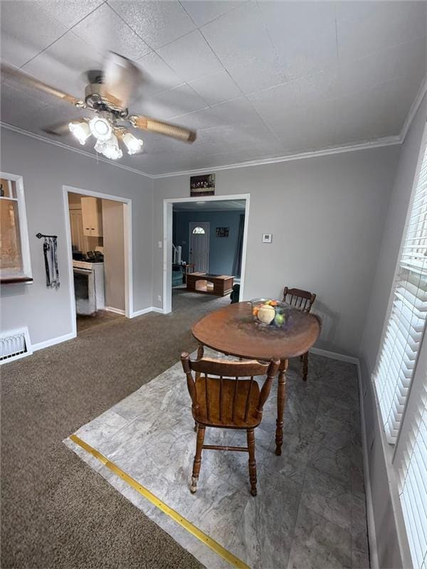 dining space with ornamental molding, ceiling fan, and carpet