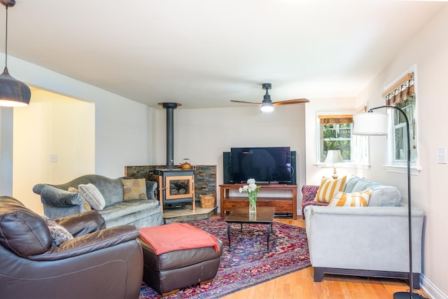 2417 Lyons St, Evanston, IL 60201 - living area featuring light wood-style flooring, a wood stove, and ceiling fan