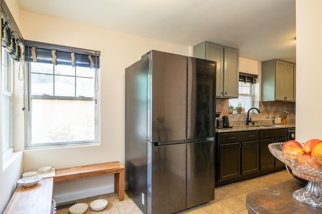 2417 Lyons St, Evanston, IL 60201 - kitchen with freestanding refrigerator, backsplash, light tile patterned floors, and light stone counters