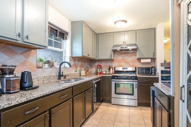 2417 Lyons St, Evanston, IL 60201 - kitchen with stainless steel range with gas stovetop, under cabinet range hood, decorative backsplash, light stone countertops, and light tile patterned floors