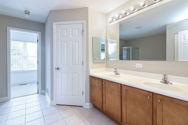 606 Ebony Dr, Oswego, IL 60543 - full bath featuring double vanity, tile patterned floors, and a shower with door