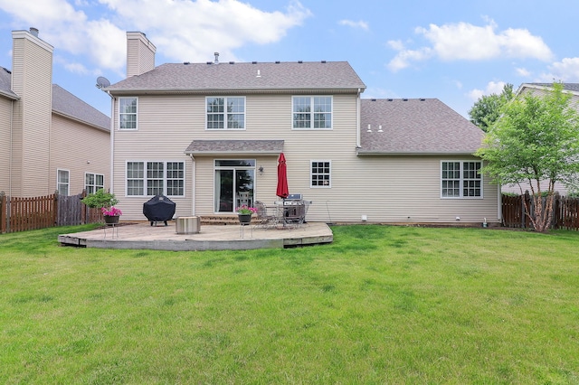 606 Ebony Dr, Oswego, IL 60543 - rear view of house with a fenced backyard, a patio, a shingled roof, and a chimney