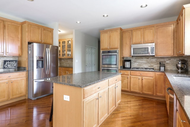 606 Ebony Dr, Oswego, IL 60543 - kitchen featuring appliances with stainless steel finishes, backsplash, light wood-type flooring, recessed lighting, and a kitchen island