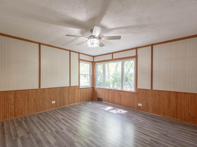 566 Glendale Ave, Wheaton, IL 60137 - unfurnished room featuring wood finished floors, a ceiling fan, wood walls, and a textured ceiling
