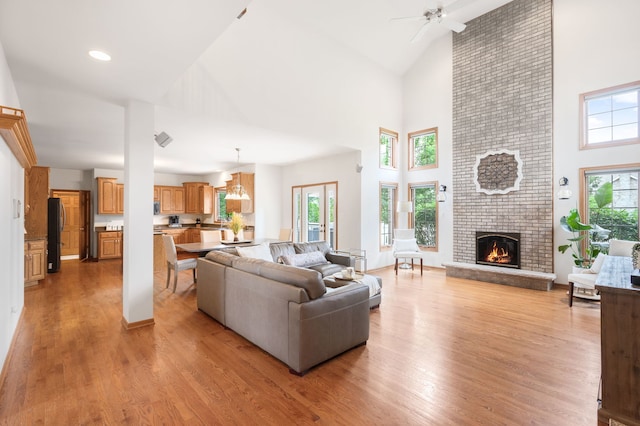 8025 Kirkcaldy Ct, Palos Heights, IL 60463 - living room featuring high vaulted ceiling, light wood-style floors, a brick fireplace, and a ceiling fan
