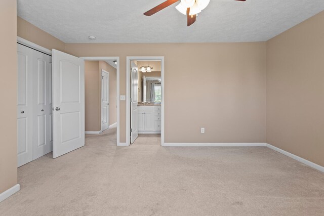 1610 Belclare Rd Unit 0, Normal, IL 61761 - unfurnished bedroom featuring light carpet, ensuite bath, a closet, ceiling fan, and a textured ceiling