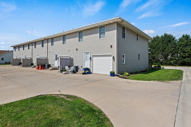 1610 Belclare Rd Unit 0, Normal, IL 61761 - back of property featuring a lawn, an attached garage, and concrete driveway
