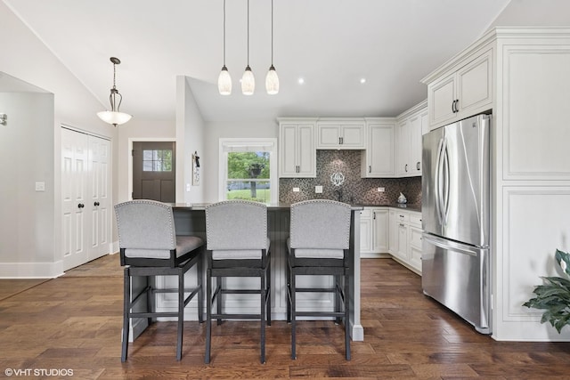 0N480 Winfield Scott Dr, Winfield, IL 60190 - kitchen featuring freestanding refrigerator, decorative backsplash, a breakfast bar, white cabinets, and a center island