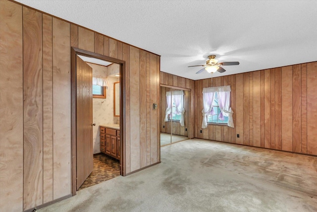 907 E Glenview Dr, Tuscola, IL 61953 - unfurnished room featuring wood walls, a ceiling fan, light carpet, and a textured ceiling