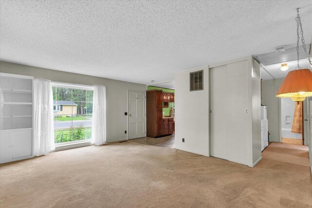 907 E Glenview Dr, Tuscola, IL 61953 - unfurnished living room with light colored carpet and a textured ceiling
