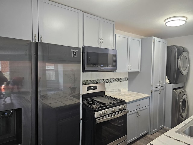 419 Sidney Ave Unit A, Glendale Heights, IL 60139 - kitchen featuring stainless steel gas range, fridge with ice dispenser, estacked washer and dryer, backsplash, and dark wood finished floors