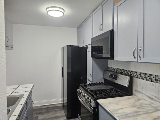 419 Sidney Ave Unit A, Glendale Heights, IL 60139 - kitchen featuring appliances with stainless steel finishes, decorative backsplash, dark wood finished floors, and light countertops