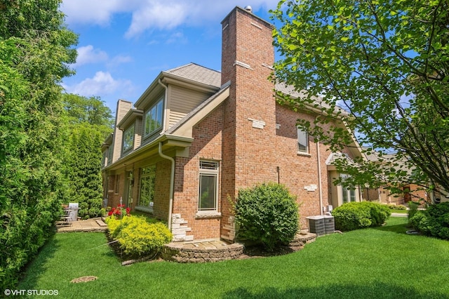 706 French Way Unit 2, Mount Prospect, IL 60056 - view of property exterior featuring a chimney, a lawn, and brick siding