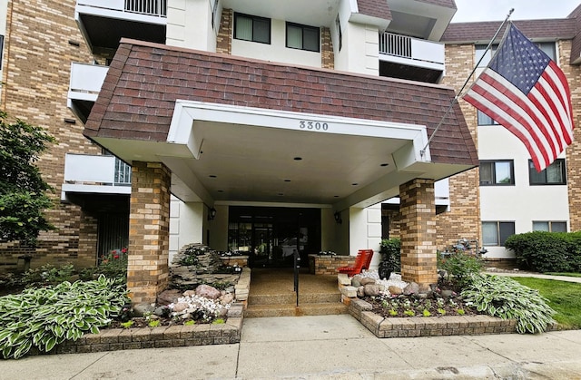 3300 N Carriageway Dr Unit 307, Arlington Heights, IL 60004 - entrance to property with a shingled roof, stucco siding, and brick siding