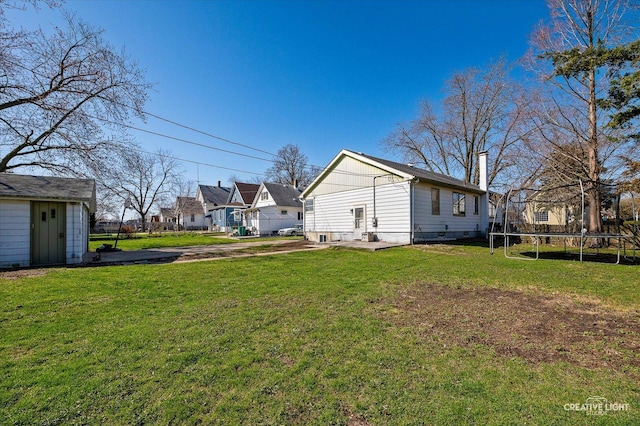 1022 Cora St, Joliet, IL 60435 - rear view of property with a trampoline, a lawn, a residential view, and a storage unit