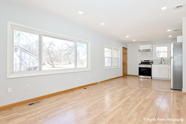 208 W Nippersink Rd, Round Lake, IL 60073 - kitchen featuring stainless steel appliances, light wood-style floors, recessed lighting, white cabinetry, and light countertops