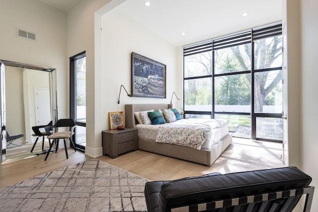 2110 Pfingsten Rd, Northbrook, IL 60062 - bedroom featuring multiple windows, light wood-style flooring, recessed lighting, and a high ceiling