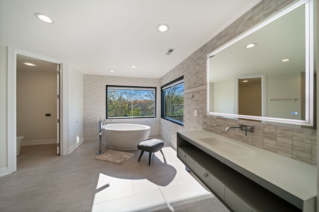 2110 Pfingsten Rd, Northbrook, IL 60062 - bathroom featuring vanity, a soaking tub, recessed lighting, tile walls, and tile patterned floors