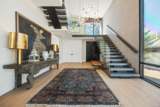 2110 Pfingsten Rd, Northbrook, IL 60062 - foyer entrance with wood finished floors, stairs, a high ceiling, and a chandelier