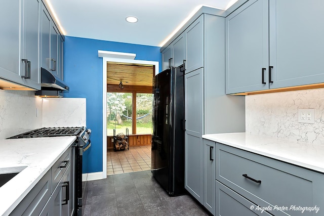 482 S Alfred Ave, Elgin, IL 60123 - kitchen with freestanding refrigerator, stainless steel gas stove, decorative backsplash, under cabinet range hood, and recessed lighting