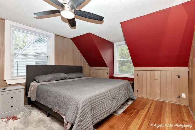 482 S Alfred Ave, Elgin, IL 60123 - bedroom with light wood-style floors, wood walls, wainscoting, lofted ceiling, and ceiling fan