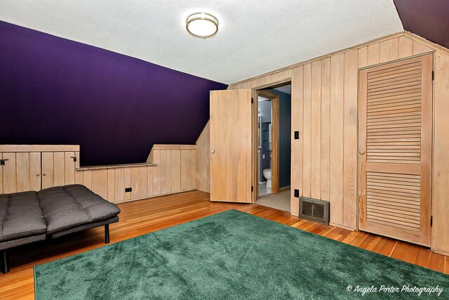 482 S Alfred Ave, Elgin, IL 60123 - living area with lofted ceiling, wood finished floors, a textured ceiling, and wooden walls