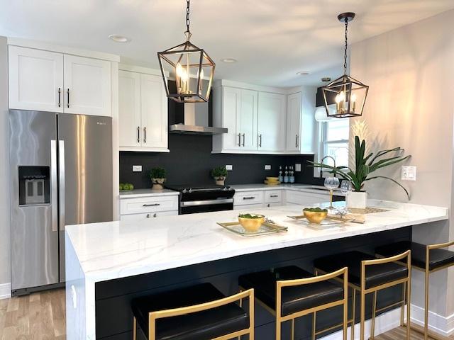 903 Jarvis Ave, Des Plaines, IL 60018 - kitchen with stainless steel fridge, a chandelier, stove, white cabinetry, and recessed lighting