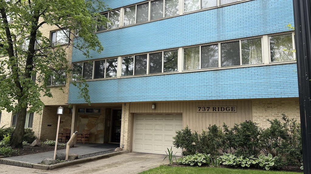737 Ridge Ave Unit 2E, Evanston, IL 60202 - view of front of house featuring an attached garage, brick siding, and driveway