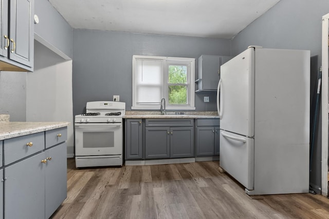 1121 Blaisdell St, Rockford, IL 61101 - kitchen with white appliances, gray cabinetry, wood finished floors, and light countertops