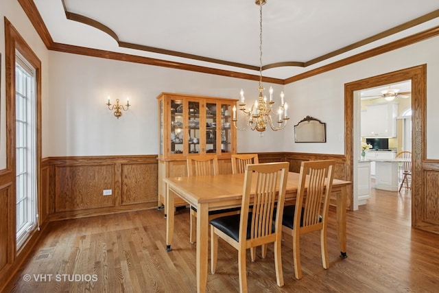 10603 Royal Porthcawl Dr, Naperville, IL 60564 - dining room with wainscoting, light wood-type flooring, crown molding, a chandelier, and ceiling fan