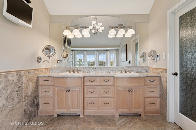 10603 Royal Porthcawl Dr, Naperville, IL 60564 - full bathroom featuring tile walls, a chandelier, double vanity, a wainscoted wall, and marble finish flooring