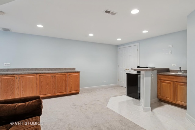 10603 Royal Porthcawl Dr, Naperville, IL 60564 - kitchen featuring recessed lighting, brown cabinetry, dark countertops, and light carpet