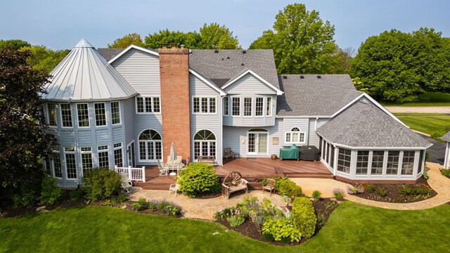 10603 Royal Porthcawl Dr, Naperville, IL 60564 - rear view of house with a sunroom, a deck, a chimney, roof with shingles, and a lawn