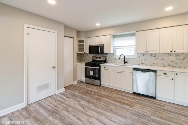 407 S York Rd, Bensenville, IL 60106 - kitchen with stainless steel appliances, decorative backsplash, light wood finished floors, white cabinetry, and recessed lighting