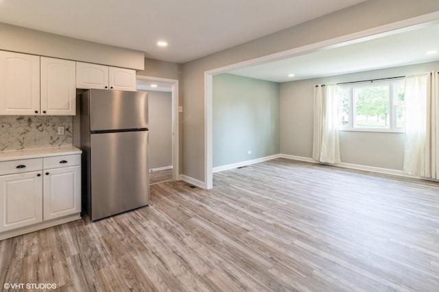 407 S York Rd, Bensenville, IL 60106 - kitchen featuring freestanding refrigerator, light countertops, white cabinets, light wood-style floors, and recessed lighting