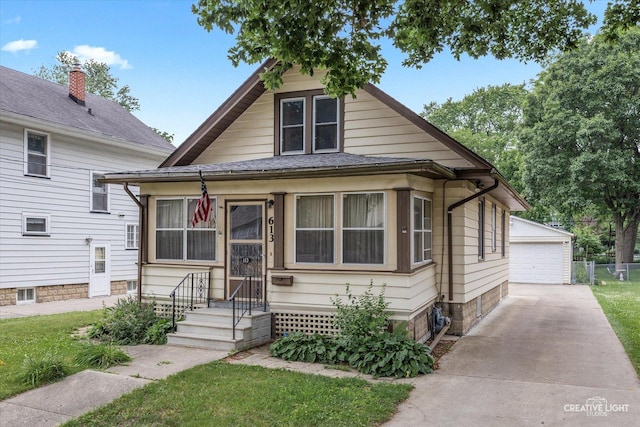 613 Jackson St, Aurora, IL 60505 - view of front of house with an outdoor structure, a detached garage, and a front lawn
