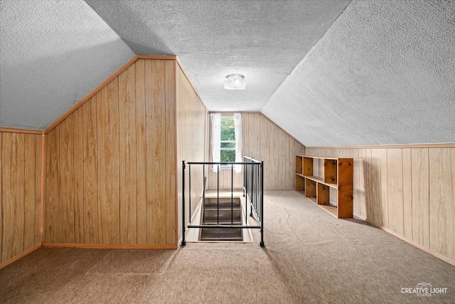 613 Jackson St, Aurora, IL 60505 - bonus room featuring a textured ceiling, vaulted ceiling, wood walls, and carpet