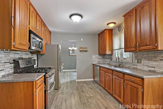 7 Kensington Ct, Streamwood, IL 60107 - kitchen featuring appliances with stainless steel finishes, tasteful backsplash, brown cabinetry, light wood-style floors, and a chandelier