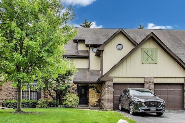 206 Country Ln, Des Plaines, IL 60016 - view of front facade with brick siding, a shingled roof, asphalt driveway, a front lawn, and an attached garage