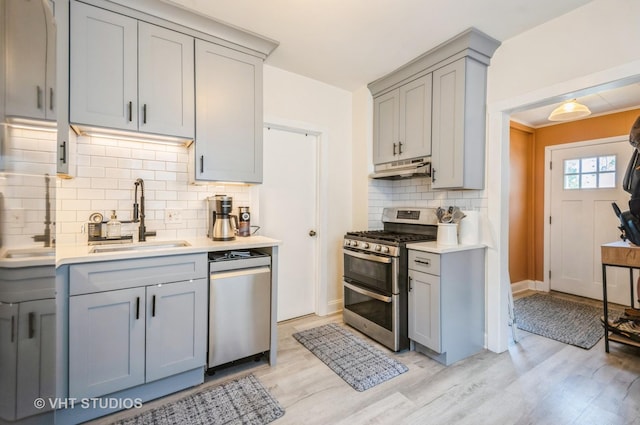 2835 S Farrell St, Chicago, IL 60608 - kitchen featuring appliances with stainless steel finishes, gray cabinetry, under cabinet range hood, and light countertops