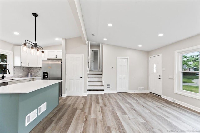 16211 Joyce Cir, South Holland, IL 60473 - kitchen with light countertops, decorative backsplash, white cabinetry, stainless steel fridge with ice dispenser, and light wood-style floors