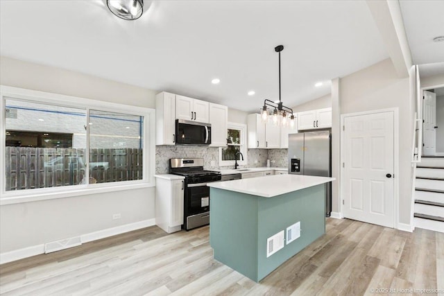 16211 Joyce Cir, South Holland, IL 60473 - kitchen with stainless steel appliances, white cabinets, light wood-style flooring, light countertops, and vaulted ceiling