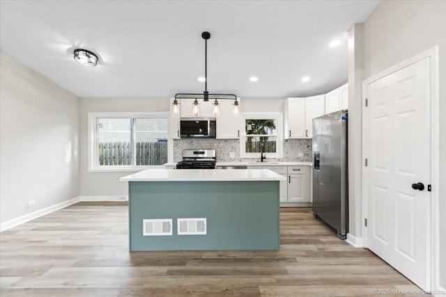 16211 Joyce Cir, South Holland, IL 60473 - kitchen featuring stainless steel appliances, white cabinetry, decorative backsplash, a kitchen island, and recessed lighting