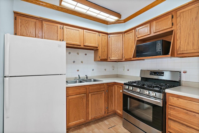 1011 Mark St, South Elgin, IL 60177 - kitchen featuring freestanding refrigerator, stainless steel range with gas stovetop, black microwave, and tasteful backsplash
