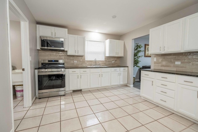 1745 N 40th Ave, Stone Park, IL 60165 - kitchen featuring appliances with stainless steel finishes, backsplash, white cabinetry, and light tile patterned floors