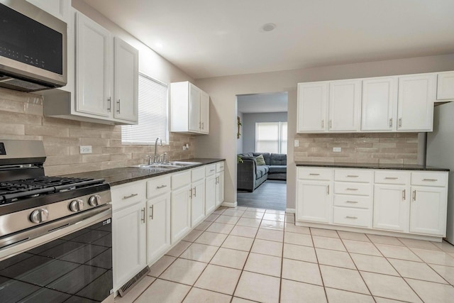 1745 N 40th Ave, Stone Park, IL 60165 - kitchen featuring appliances with stainless steel finishes, white cabinetry, backsplash, and light tile patterned floors